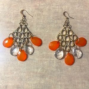 Pierced earrings with orange and clear lucite oval hanging discs